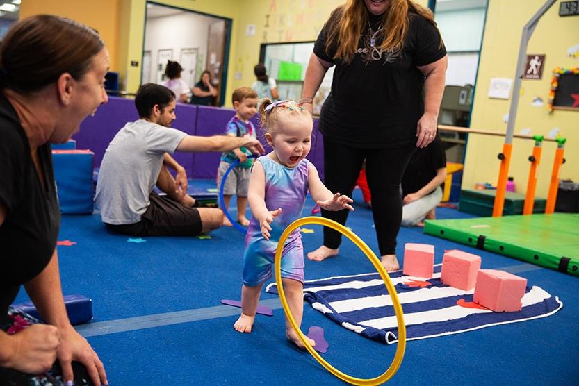 little girl chasing a hula hoop